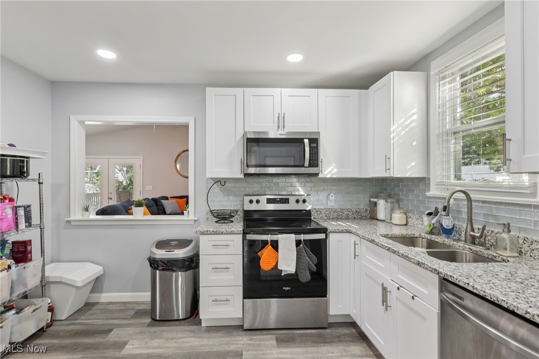 1503 Oakmount Road South Euclid, OH 44121 - Photo 21 of 50 Kitchen with appliances with stainless steel finishes, white cabinetry, light stone counters, and recessed lighting