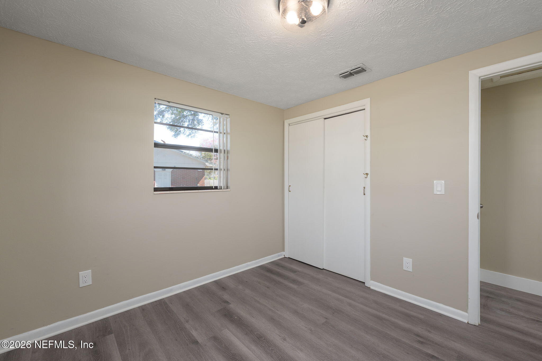 724 Miltondale Road Macclenny, FL 32063 - Photo 23 of 31 a view of an empty room with wooden floor and a window