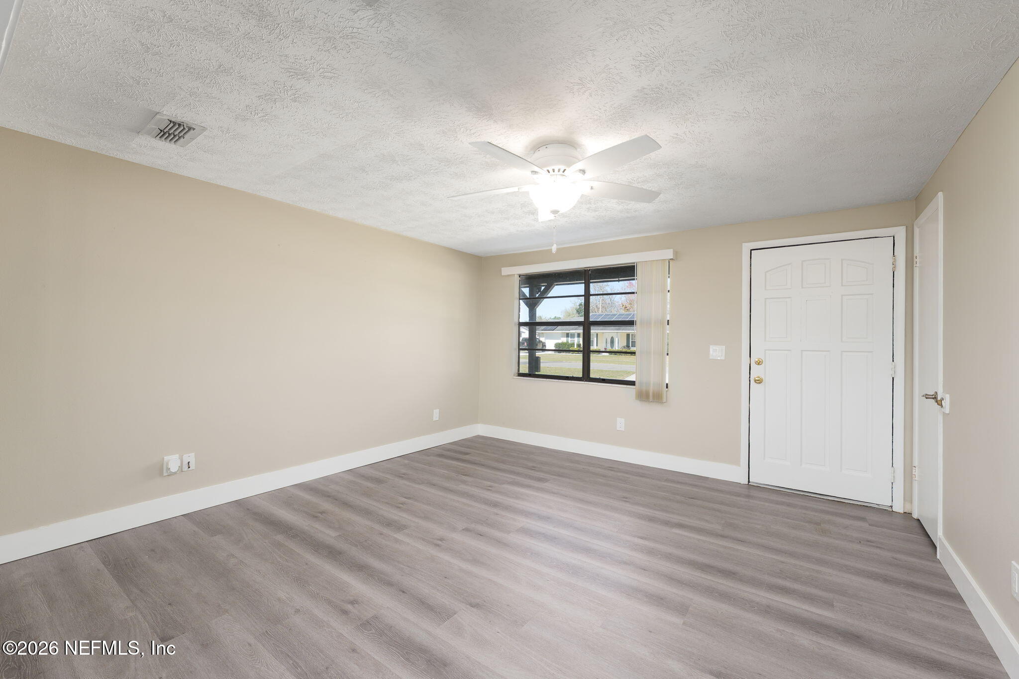 724 Miltondale Road Macclenny, FL 32063 - Photo 7 of 31 wooden floor in an empty room with a window