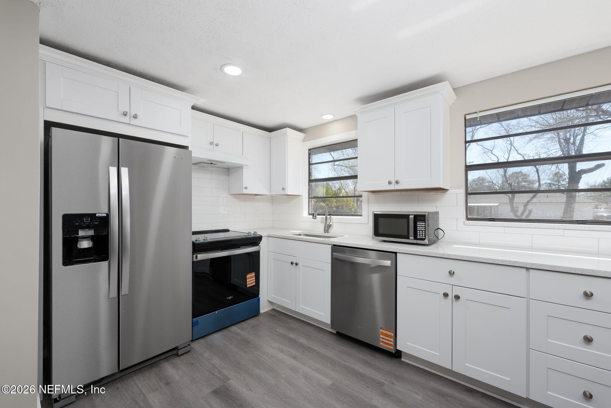 724 Miltondale Road Macclenny, FL 32063 - Photo 9 of 31 a kitchen with white cabinets and stainless steel appliances