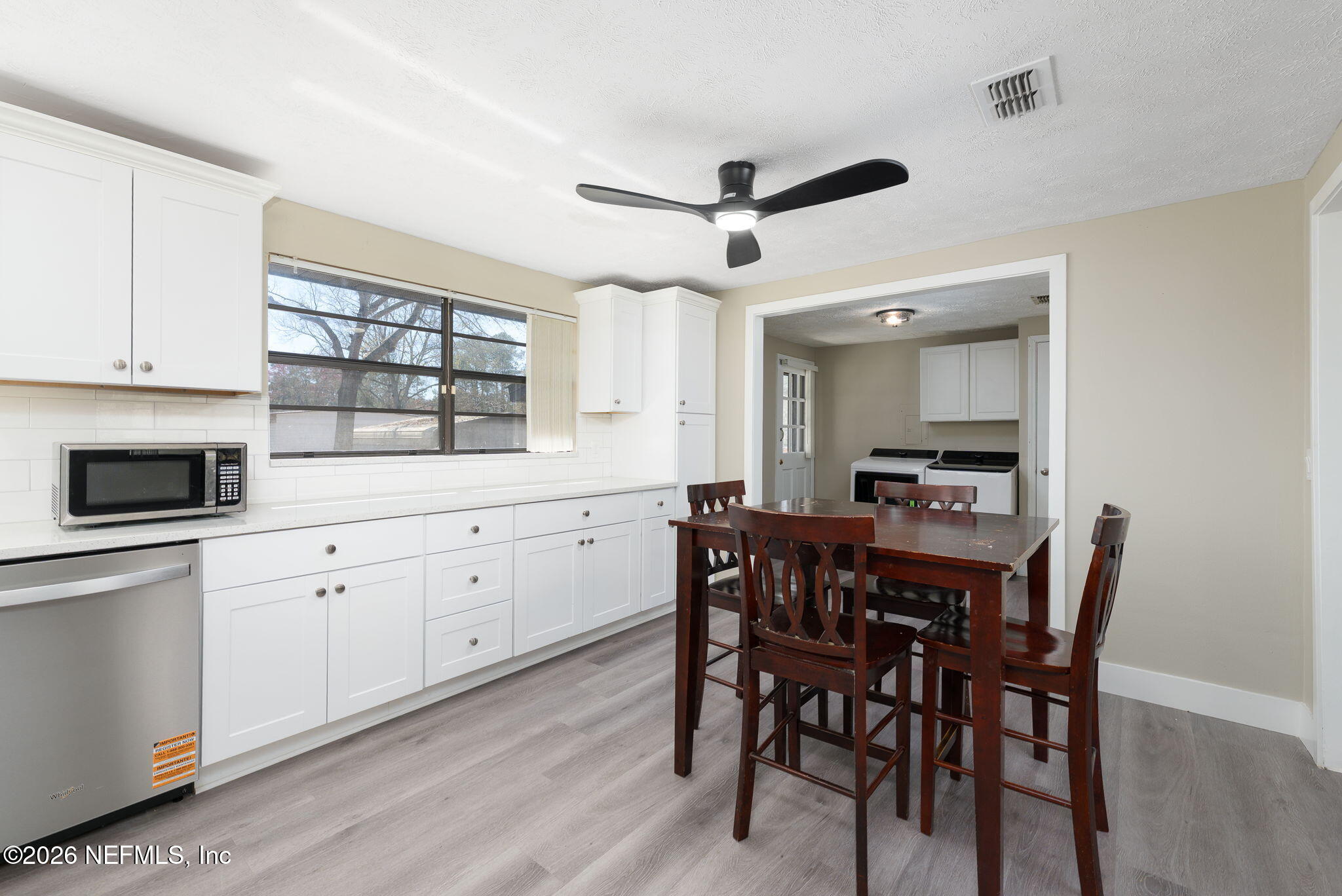 724 Miltondale Road Macclenny, FL 32063 - Photo 10 of 31 a kitchen with a dining table chairs cabinets and stainless steel appliances