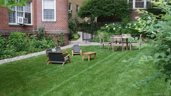 a view of a chair and table in backyard of the house