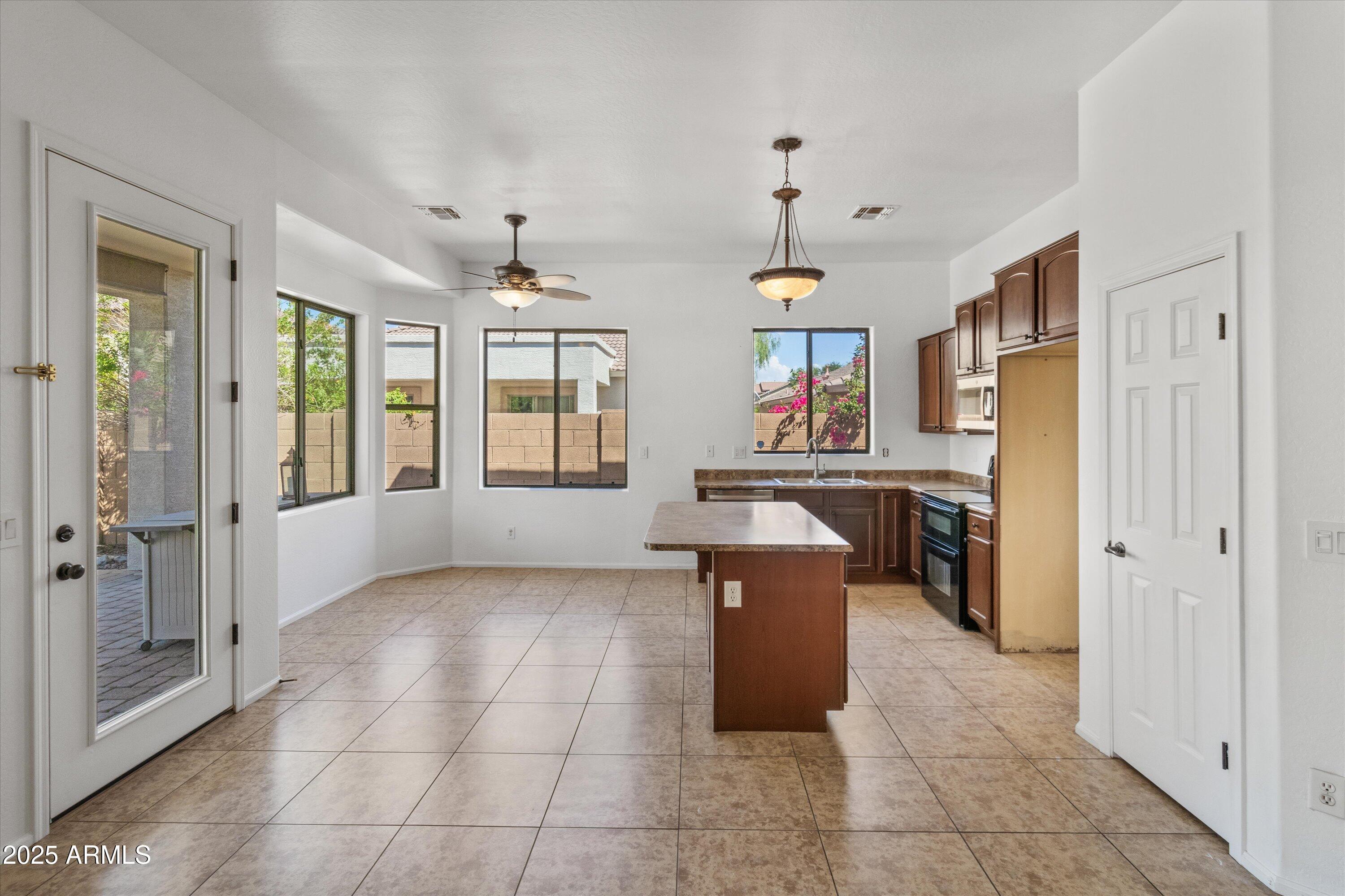 45076 West Rhea Road Maricopa, AZ 85139 - Photo 14 of 43 a kitchen with granite countertop a sink and a refrigerator