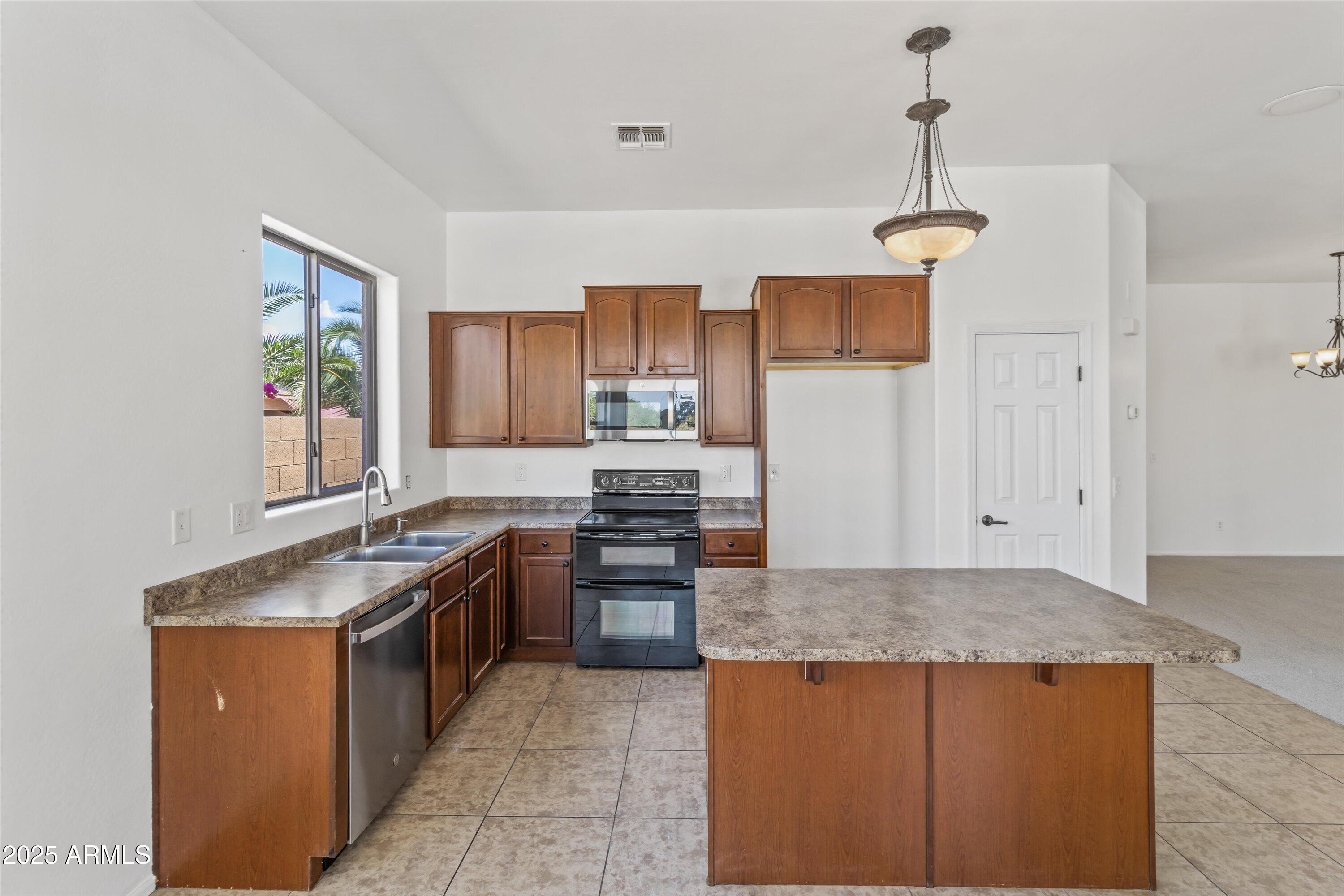 45076 West Rhea Road Maricopa, AZ 85139 - Photo 15 of 43 a kitchen with granite countertop a sink and stainless steel appliances