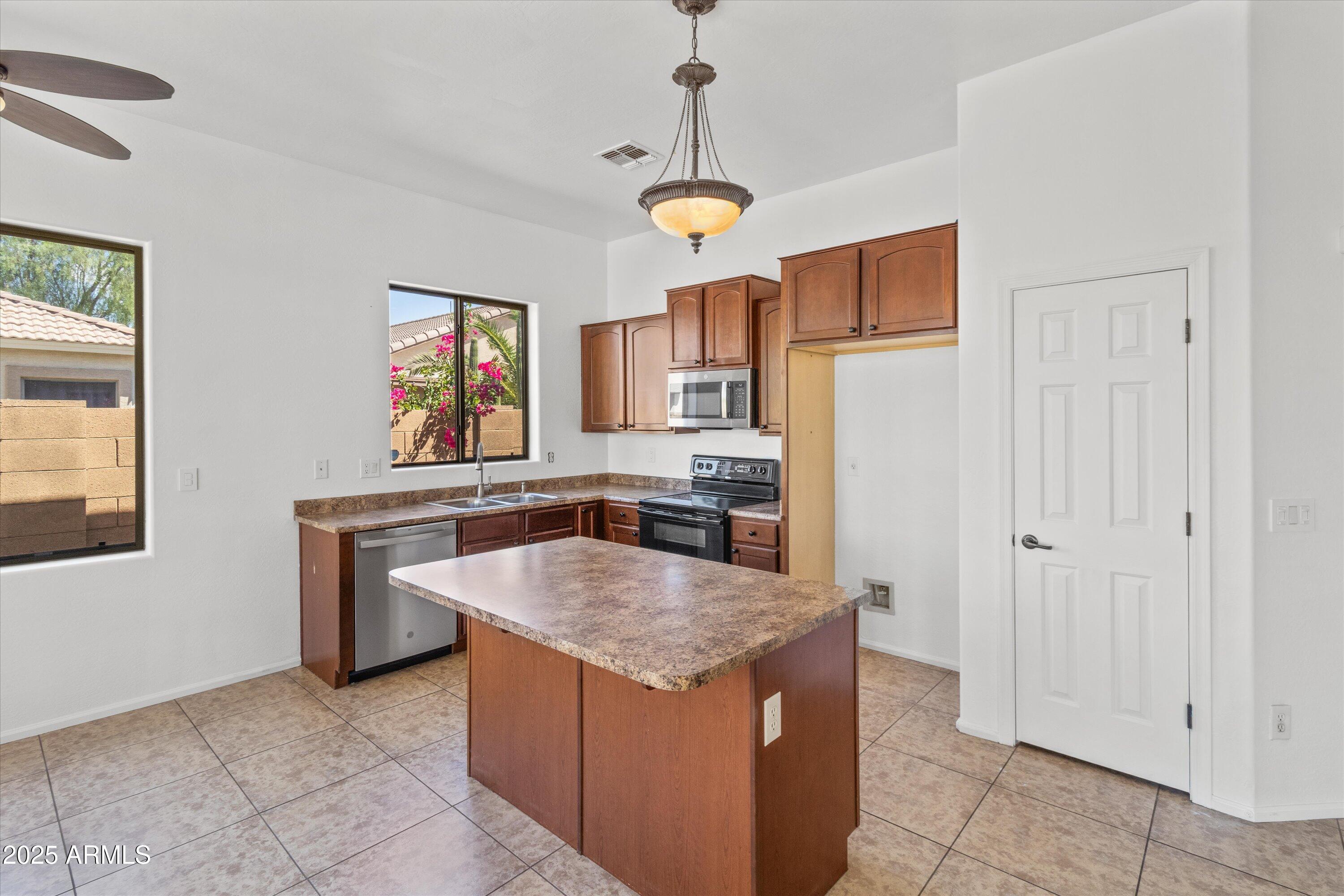 45076 West Rhea Road Maricopa, AZ 85139 - Photo 3 of 43 a kitchen with stainless steel appliances granite countertop a stove a refrigerator a sink and dishwasher
