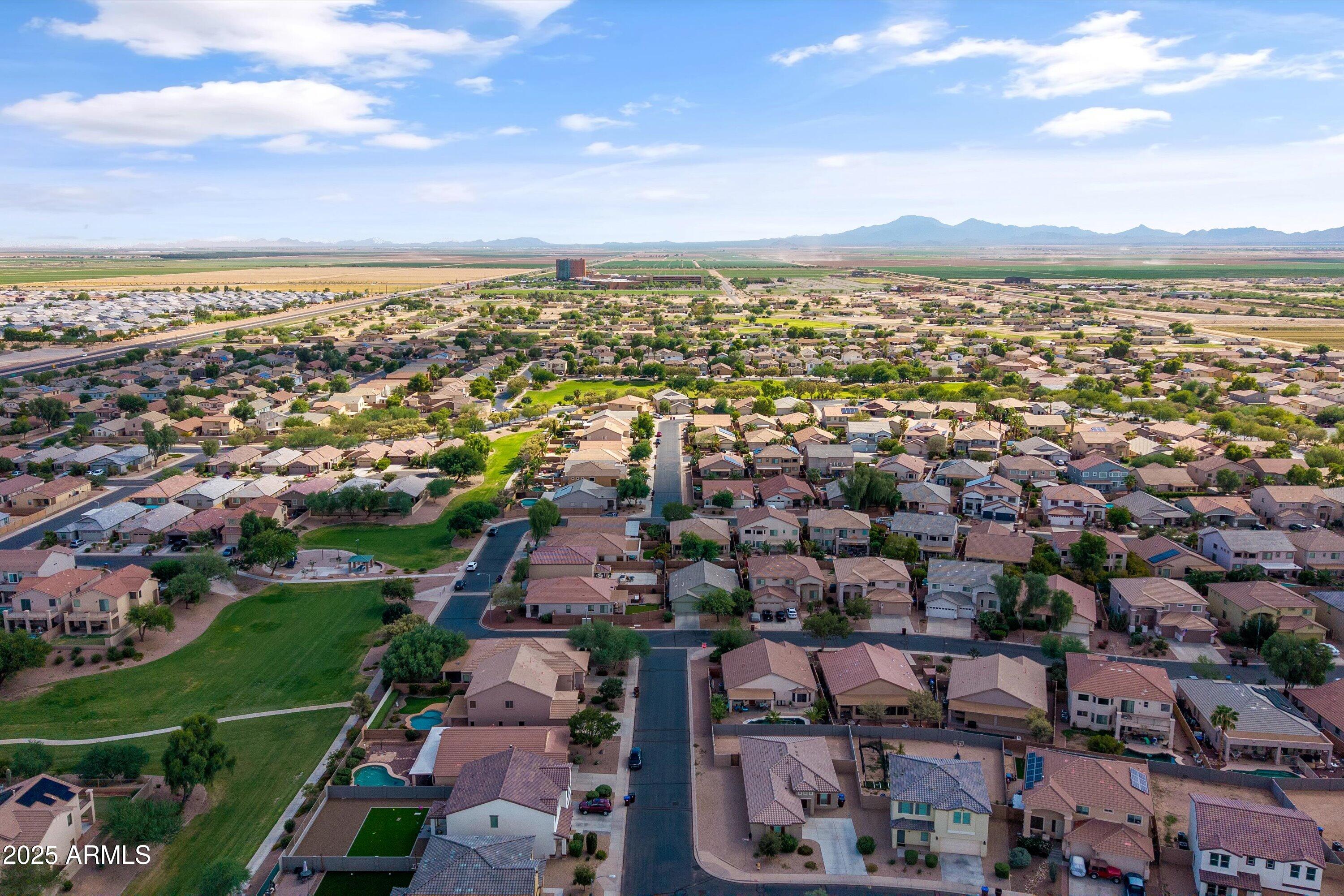 45076 West Rhea Road Maricopa, AZ 85139 - Photo 42 of 43 an aerial view of a city with lots of residential buildings and mountain view in back