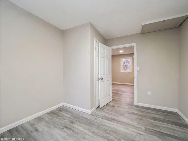 an empty room with wooden floor & windows