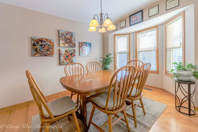 a view of a dining room with furniture a chandelier and wooden floor