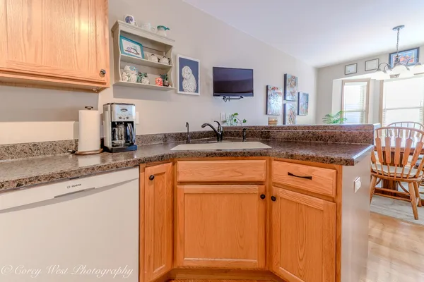 a kitchen with granite countertop a sink stainless steel appliances white cabinets and a window