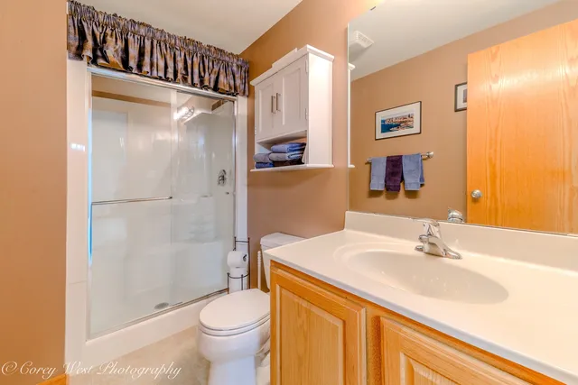 a bathroom with a granite countertop sink toilet and shower