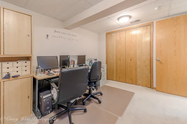 a view of a workspace with furniture and a refrigerator