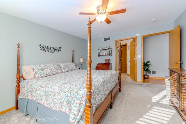 a bedroom with a large bed and a chandelier