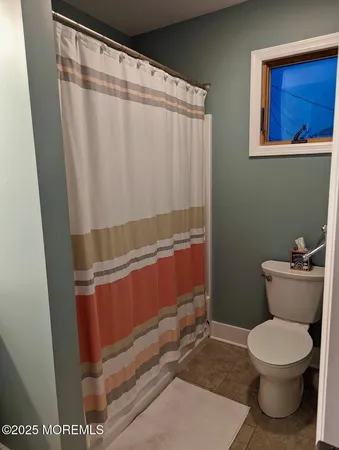 a bathroom with a toilet and a shower curtain