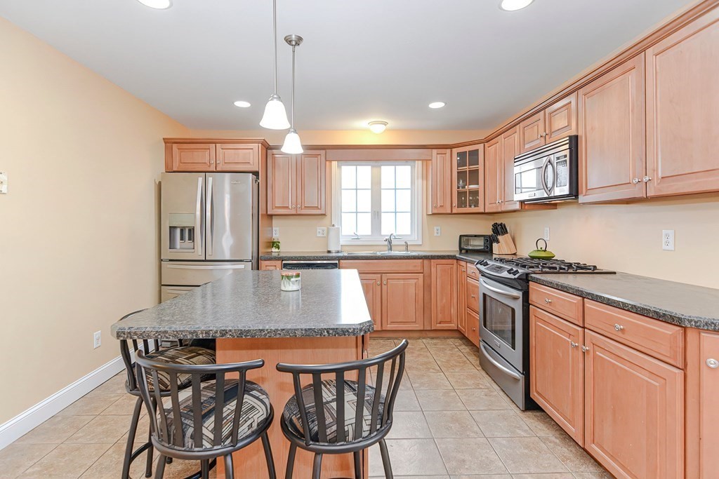 522 Detroit Street Fall River, MA 02721 - Photo 6 of 32 a kitchen with stainless steel appliances granite countertop a sink a stove a dining table and chairs