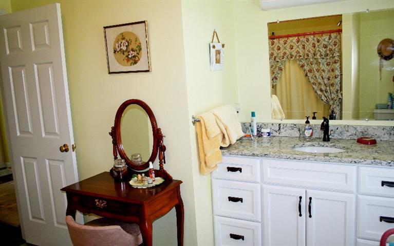 275 Quasons Path Brewster, MA 02631 - Photo 23 of 32 a bathroom with a granite countertop sink a mirror and vanity