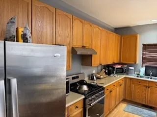 a kitchen with stainless steel appliances a stove a sink and a refrigerator