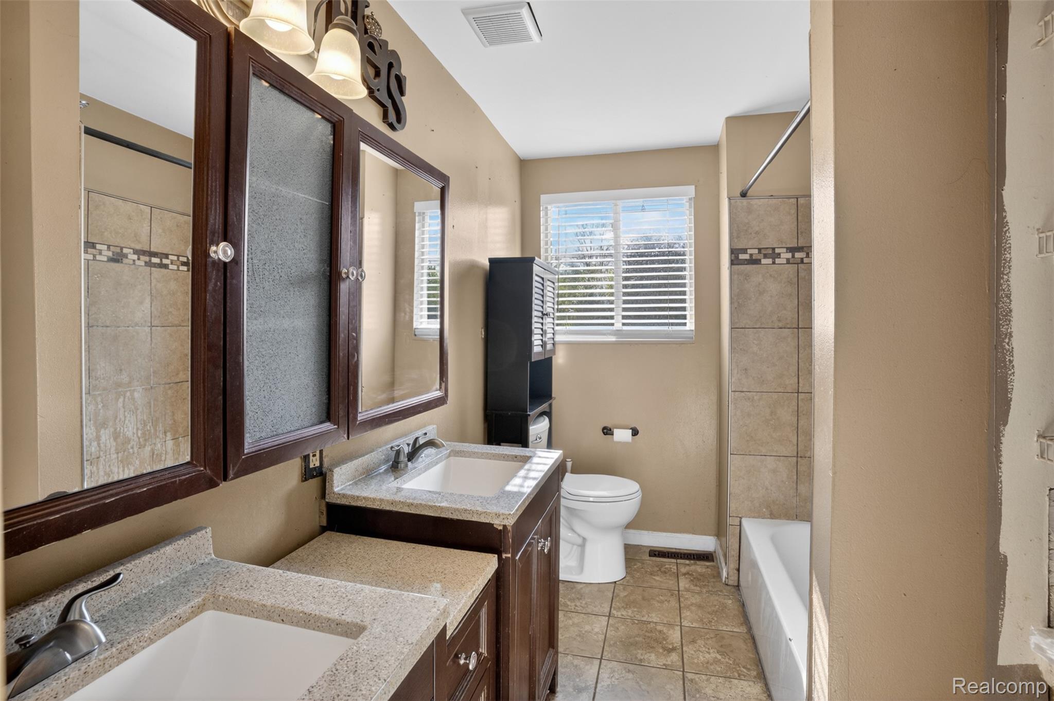 6169 Neff Road Mount Morris, MI 48458 - Photo 13 of 49 Full bath with two vanities, shower / bath combination, and light tile patterned flooring