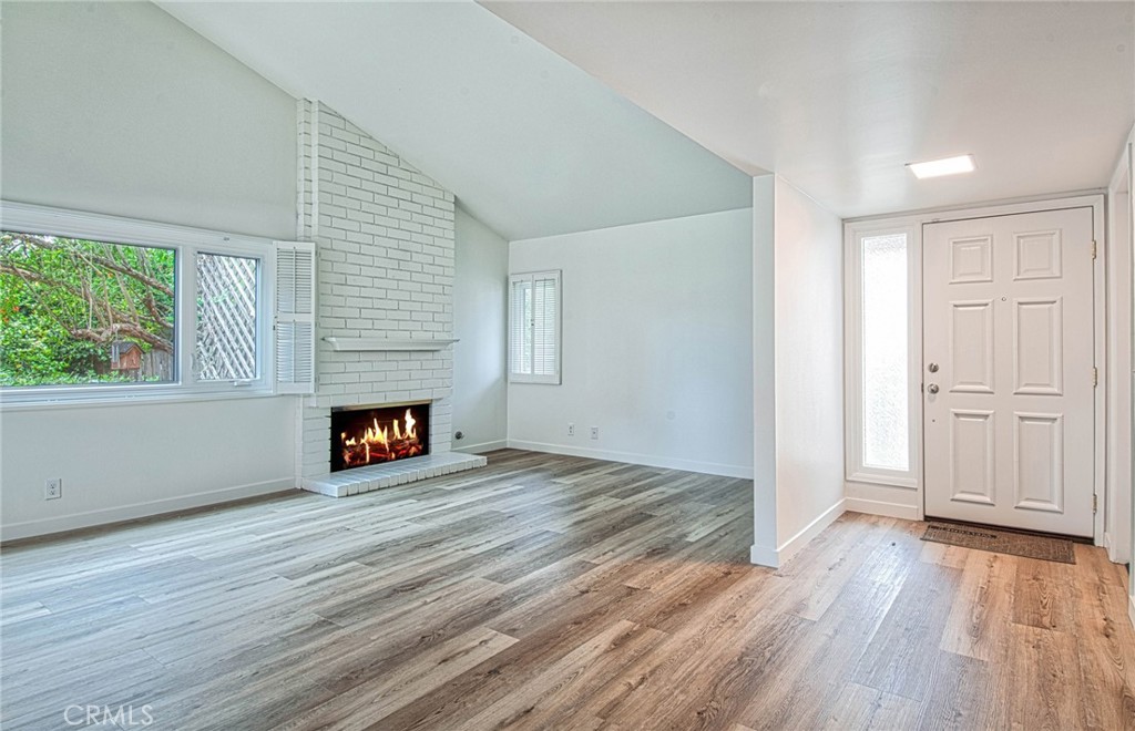 6061 Sierra Bravo Road Irvine, CA 92603 - Photo 4 of 22 an empty room with wooden floor fireplace and windows