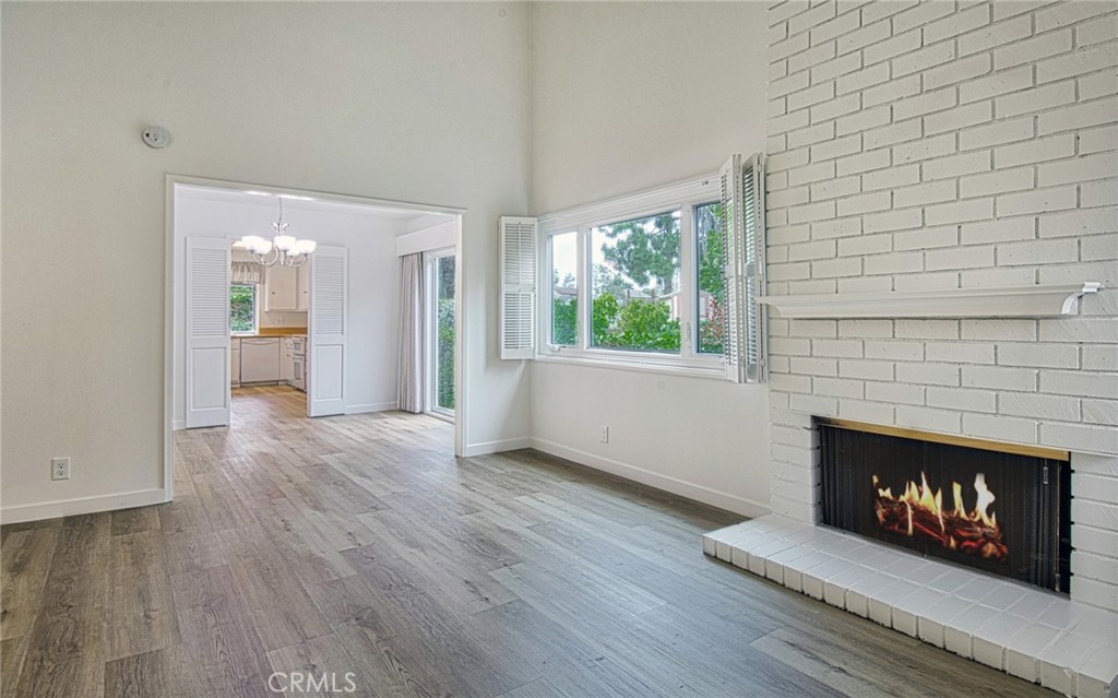 6061 Sierra Bravo Road Irvine, CA 92603 - Photo 6 of 22 an empty room with wooden floor fireplace and windows