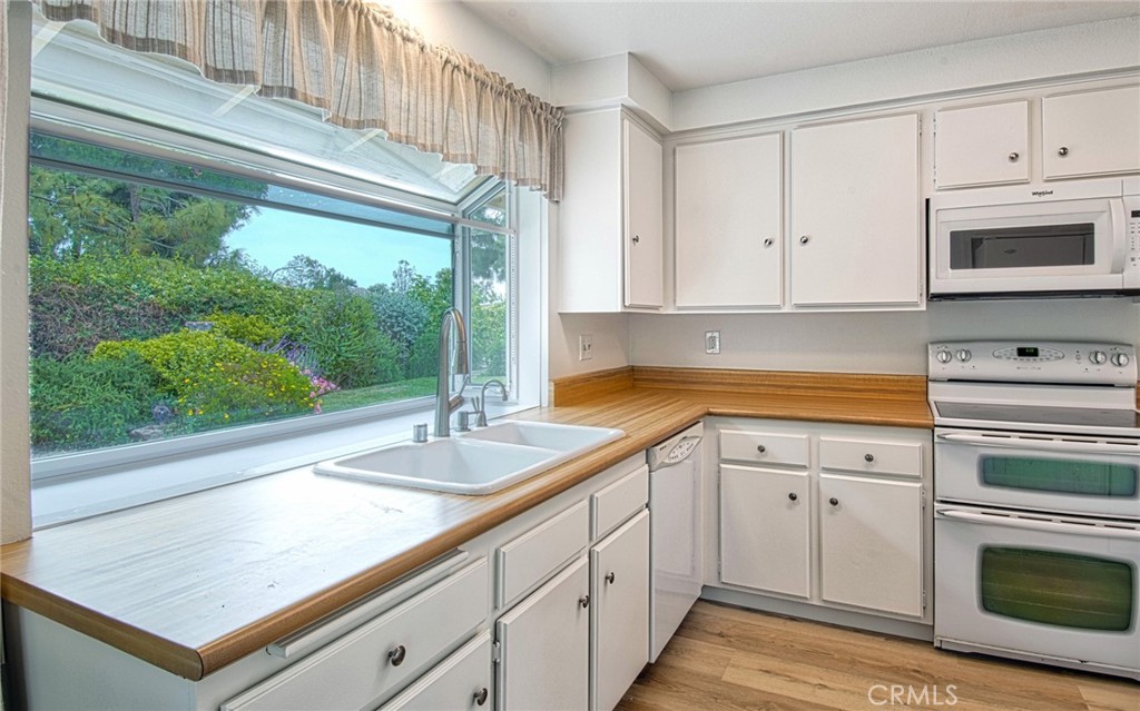 6061 Sierra Bravo Road Irvine, CA 92603 - Photo 7 of 22 a kitchen with granite countertop a sink stainless steel appliances white cabinets and a window