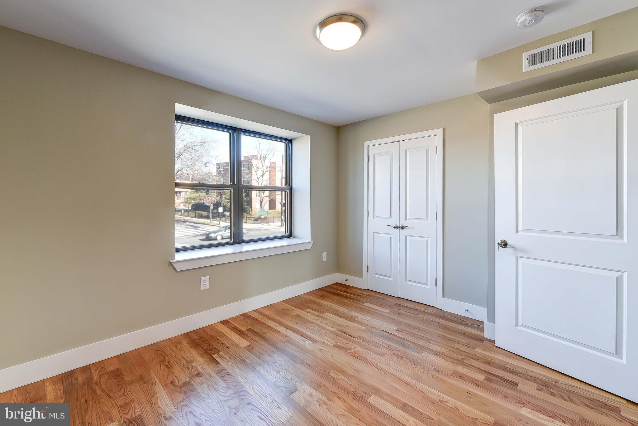 2031 Benning Road Northeast, Unit B Washington, DC 20002 - Photo 8 of 22 a view of an empty room with wooden floor and a window