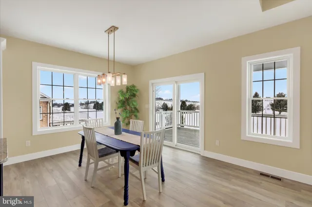 a dining room with furniture a chandelier and wooden floor