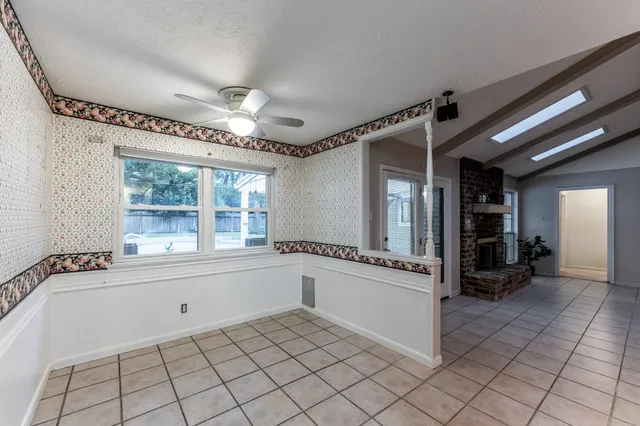 a bathroom with a tub a sink and a large mirror next to a window