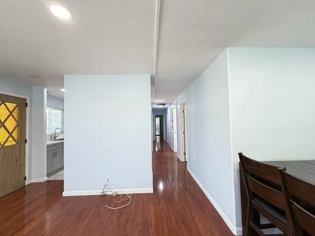 a view of a hallway with wooden floor and staircase