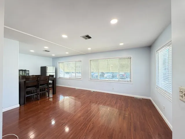 an empty room with wooden floor and furniture
