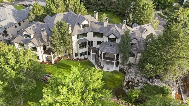 a white house with a big yard and large trees