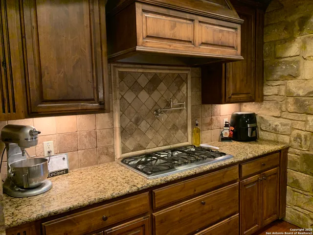 a kitchen with granite countertop cabinets and stove top oven