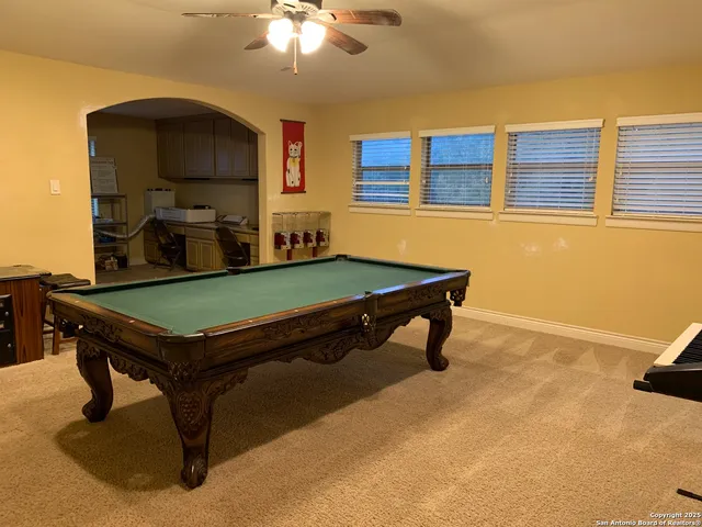 a room with pool table and windows