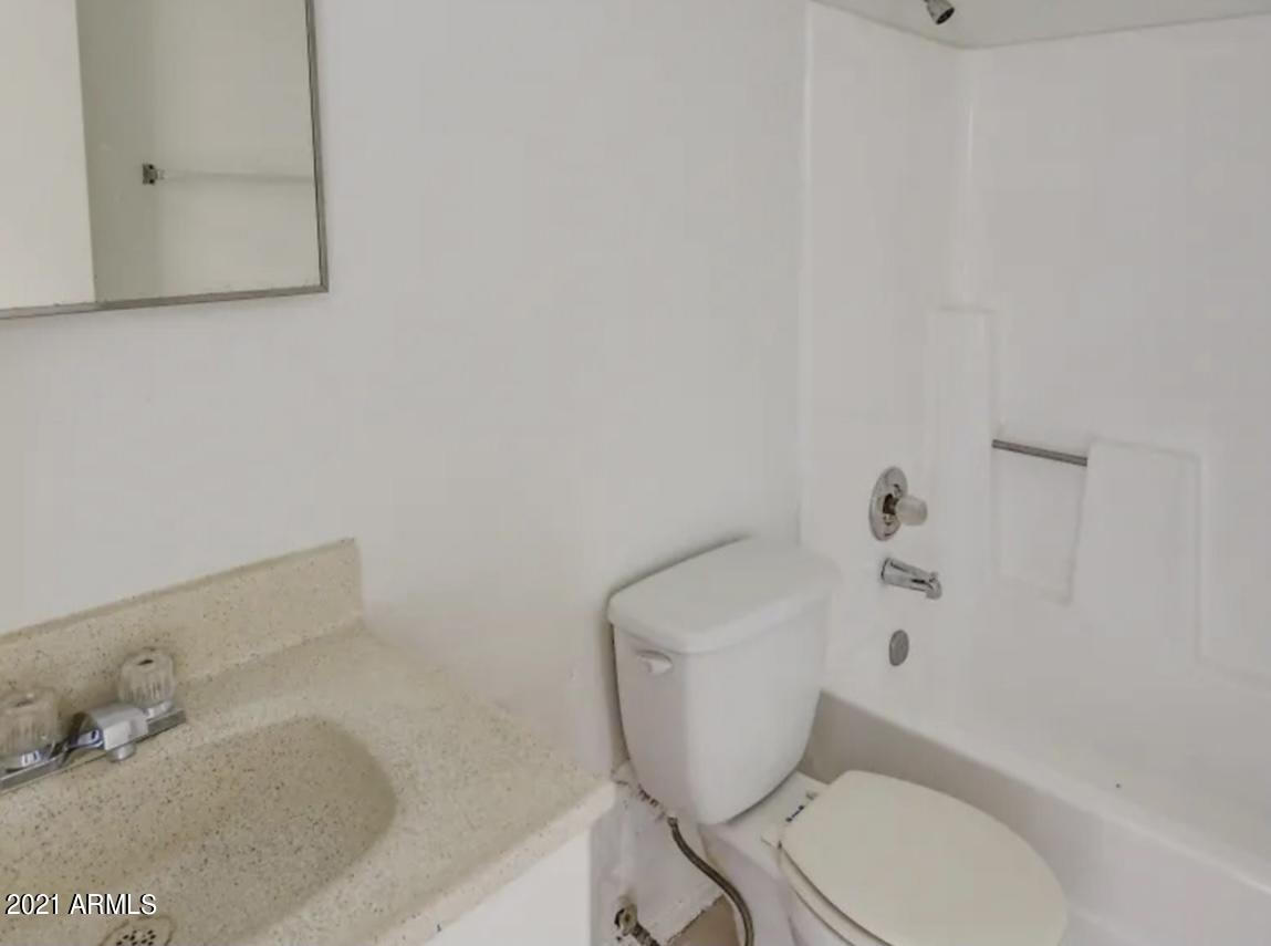1709 West Mountain View Road, Unit 105 Phoenix, AZ 85021 - Photo 6 of 7 a white toilet sitting next to a bath tub