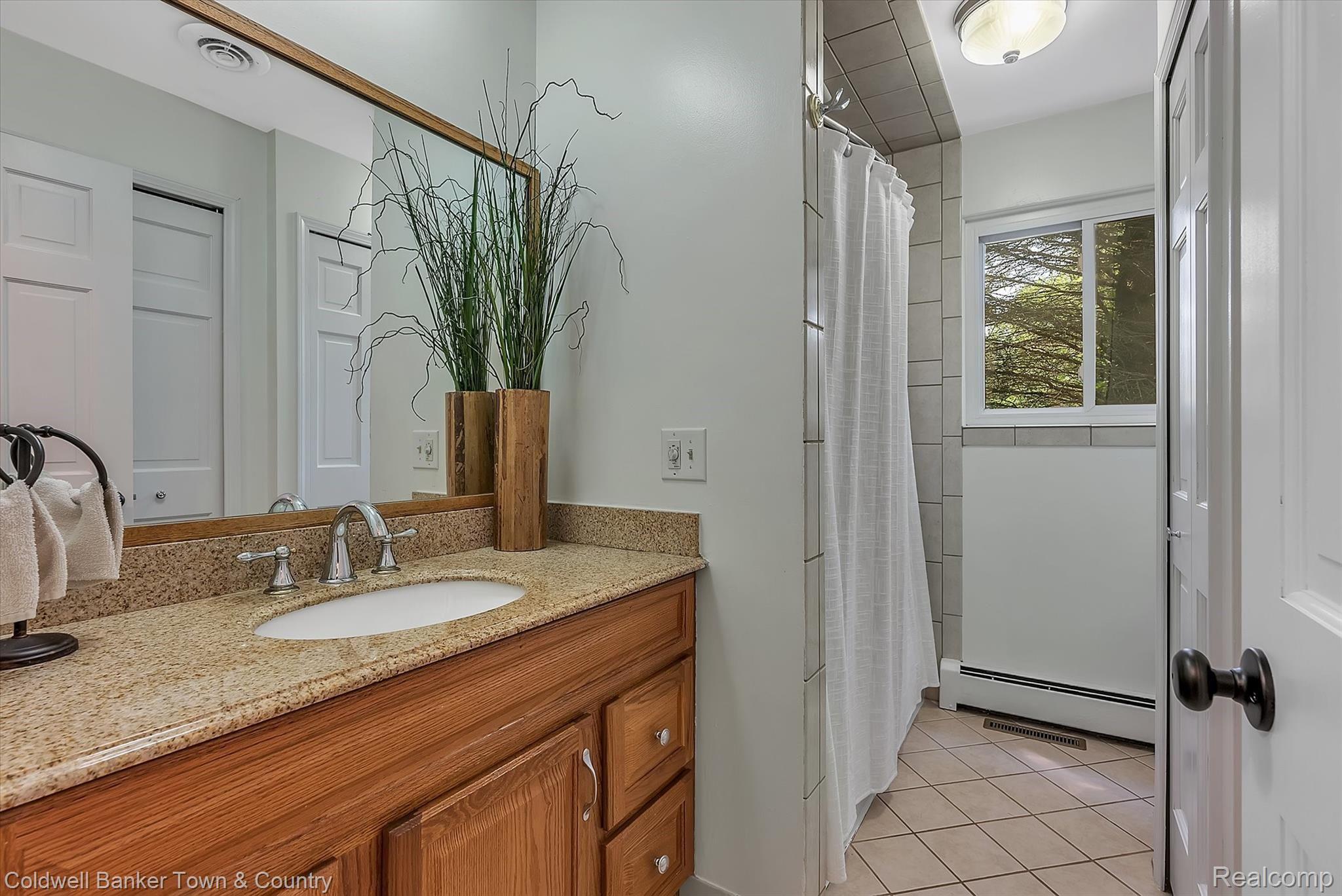 5431 Evans Road Holly, MI 48442 - Photo 31 of 81 Main Bath with granite counter, ceramic tile floor, and tile wall shower with pristine tub!