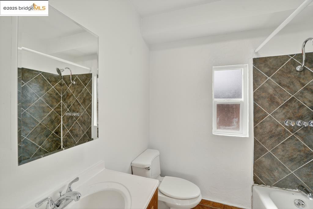 4114 East 17th Street Oakland, CA 94601 - Photo 11 of 39 a white toilet sitting next to a bathroom sink and tub