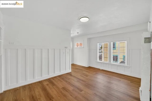 a view of a kitchen with wooden floor and a refrigerator
