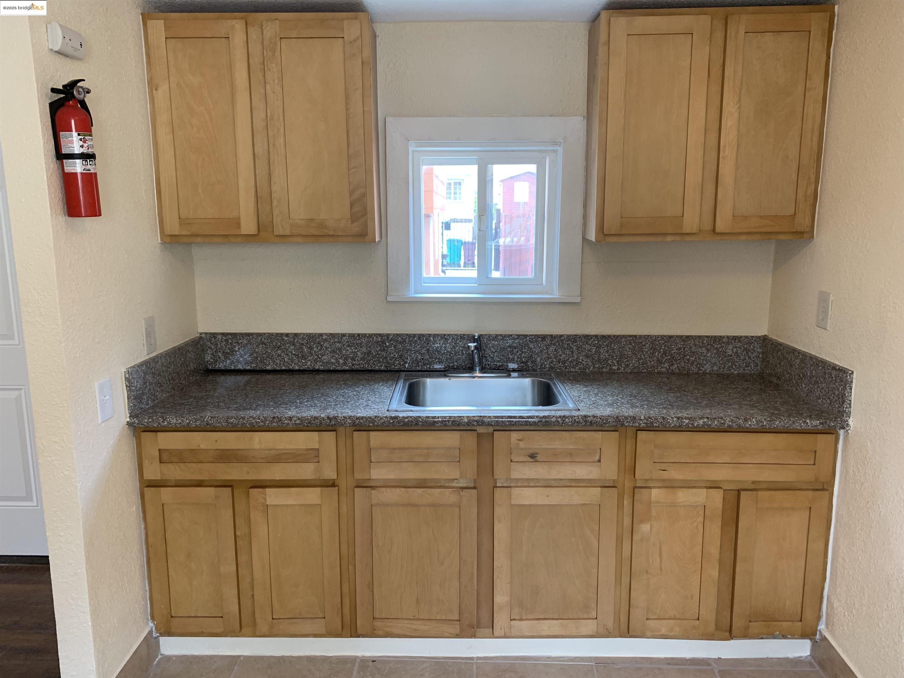 4114 East 17th Street Oakland, CA 94601 - Photo 25 of 39 a kitchen with a sink cabinets and a window