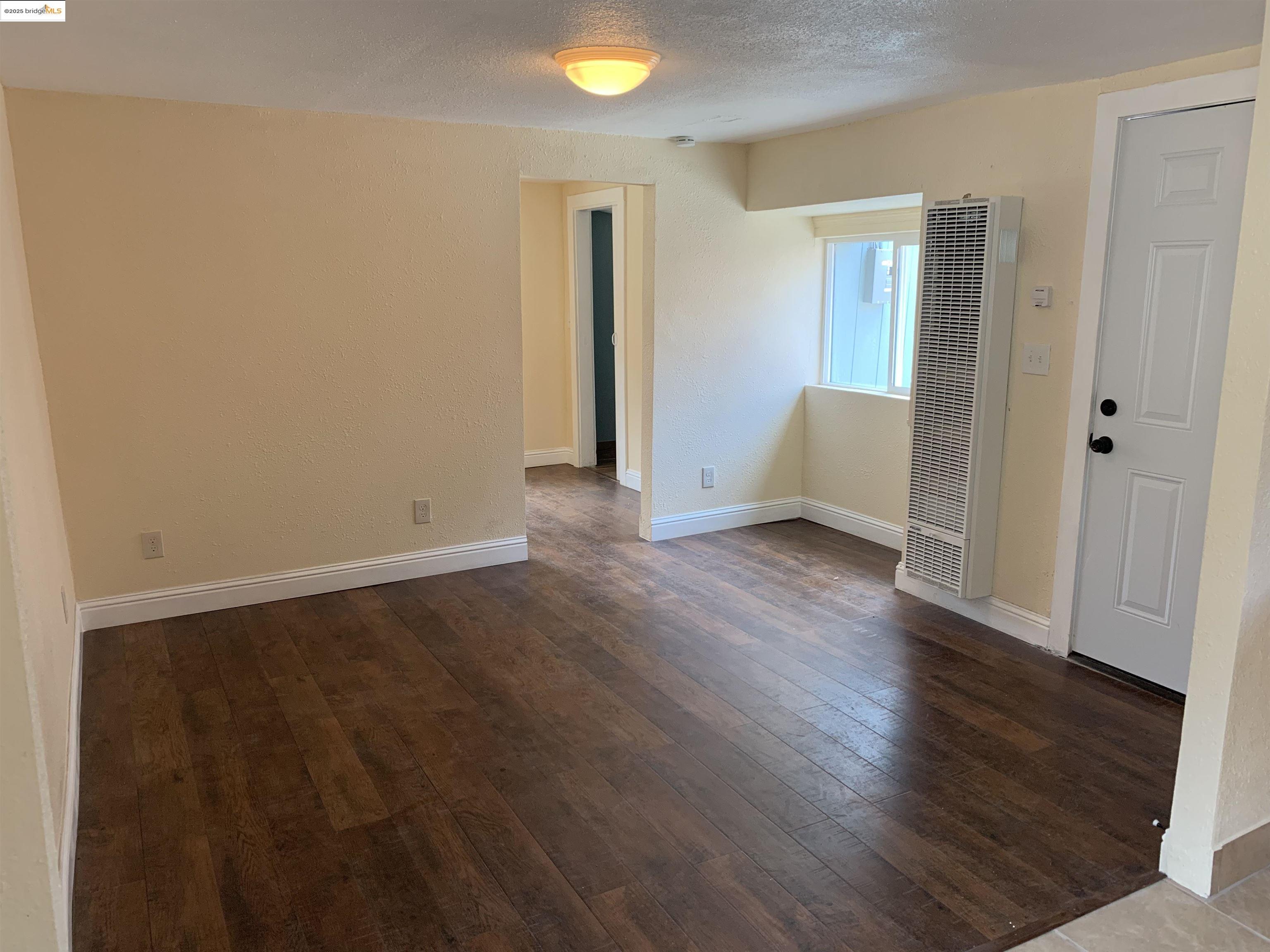 4114 East 17th Street Oakland, CA 94601 - Photo 28 of 39 an empty room with wooden floor and windows