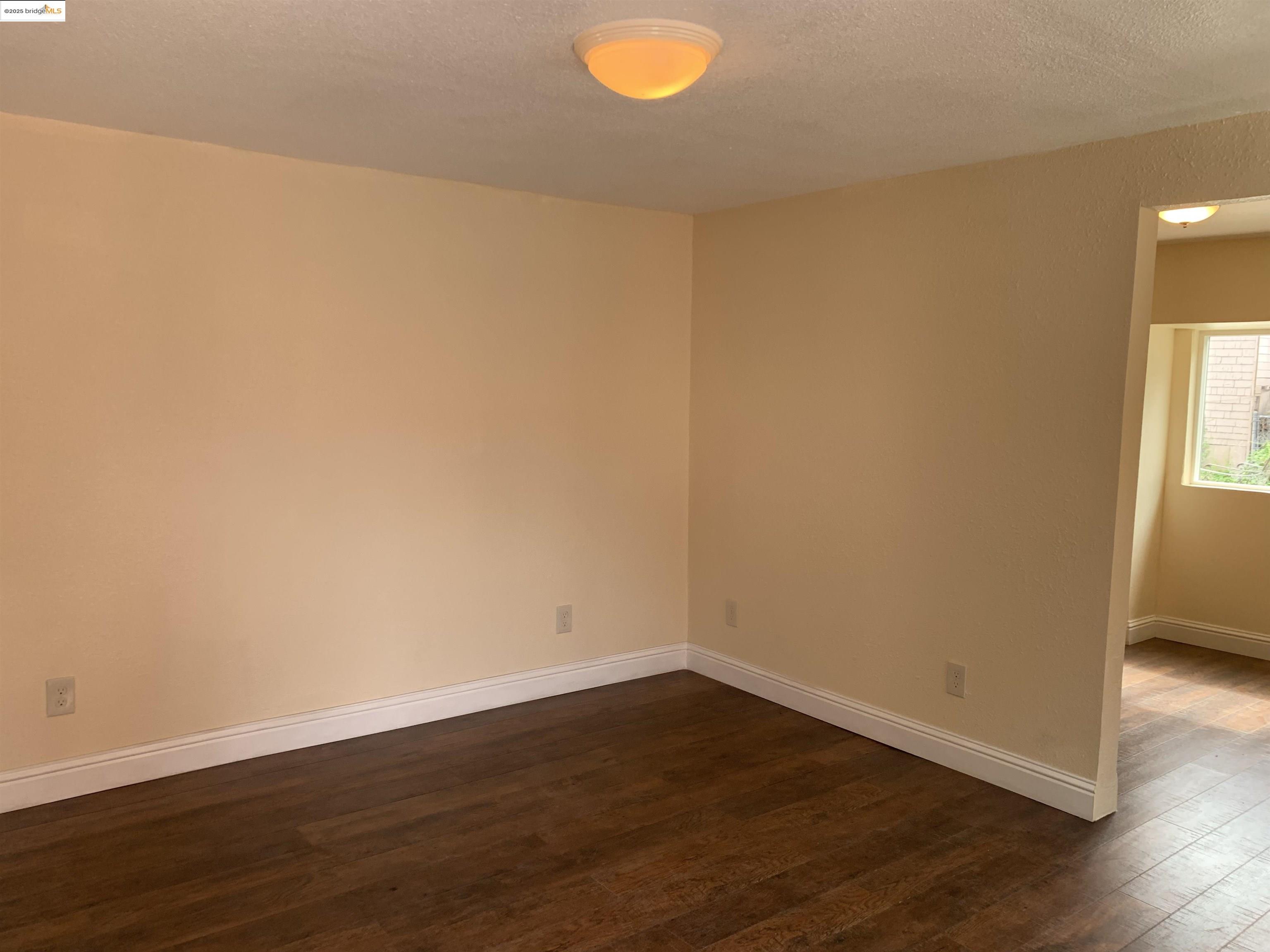 4114 East 17th Street Oakland, CA 94601 - Photo 31 of 39 a view of empty room with wooden floor and fan