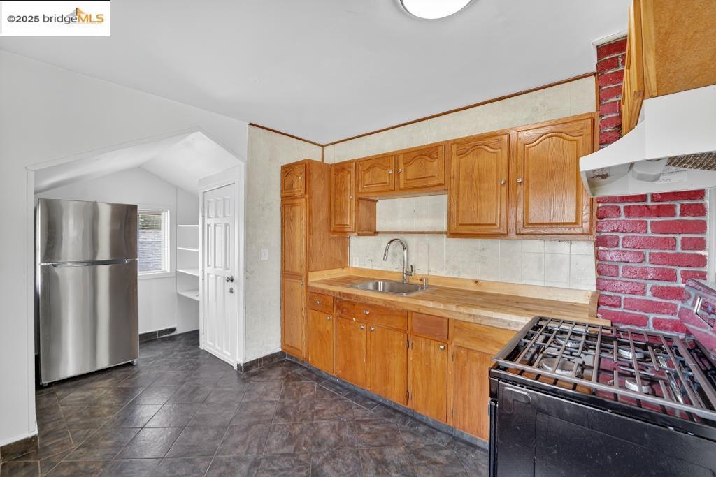 4114 East 17th Street Oakland, CA 94601 - Photo 9 of 39 a kitchen that has a lot of cabinets in it and stainless steel appliances