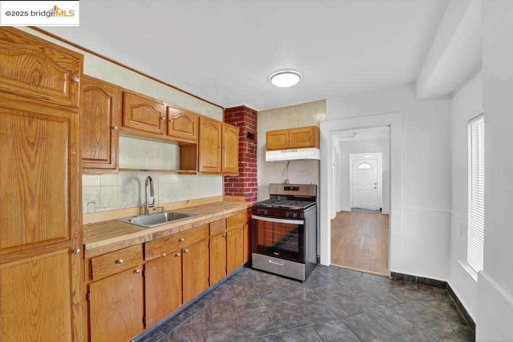 4114 East 17th Street Oakland, CA 94601 - Photo 10 of 39 a kitchen with stainless steel appliances granite countertop a sink stove and refrigerator