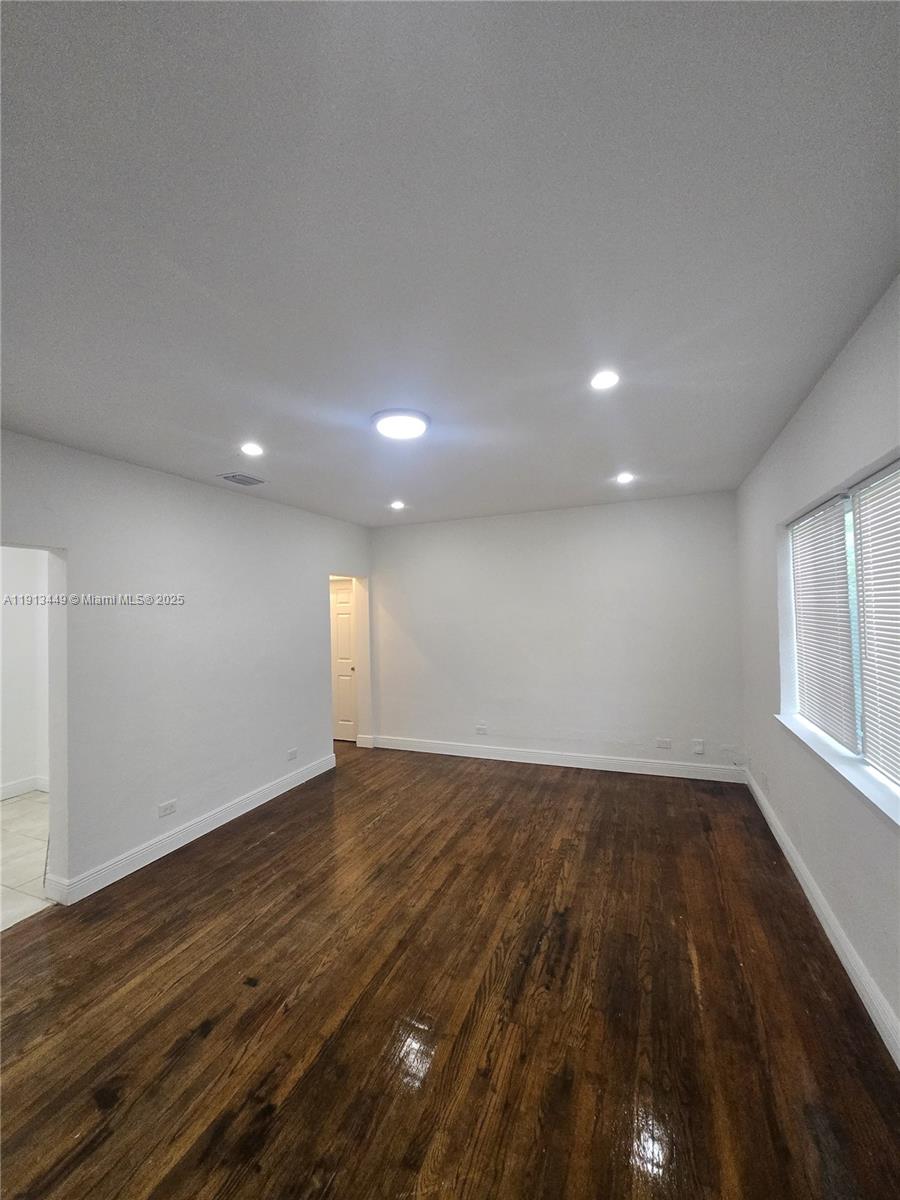 851 80th Street, Unit 4 Miami Beach, FL 33141 - Photo 9 of 9 an empty room with wooden floor and windows
