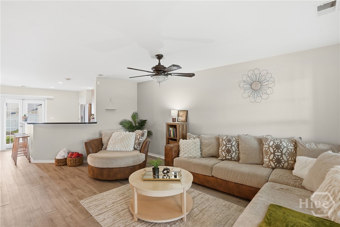 61 Timber Crest Court Savannah, GA 31407 - Photo 13 of 29 Living room with ceiling fan, neutral walls, wood-look flooring, and open view toward the kitchen
