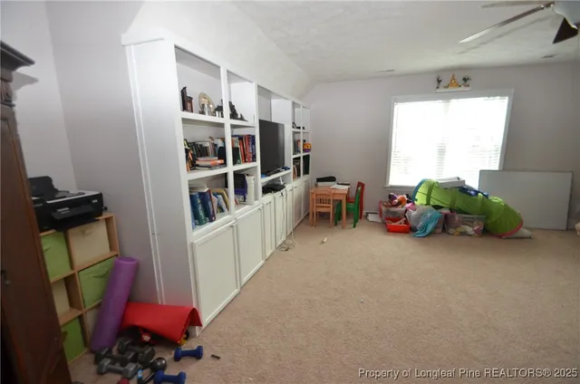a living room with furniture and a book shelf