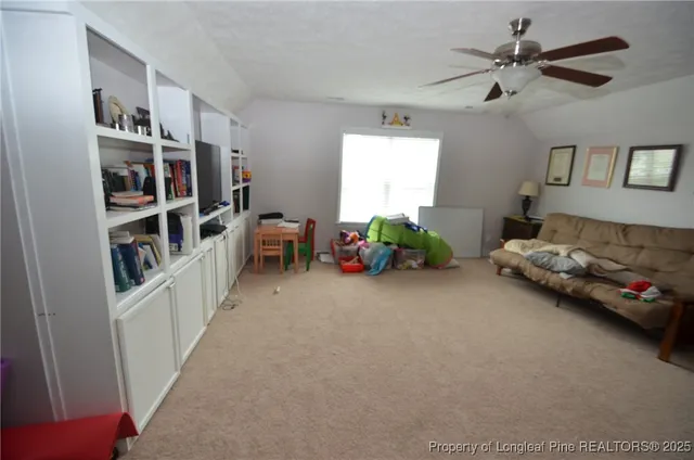 a living room with furniture and a book shelf