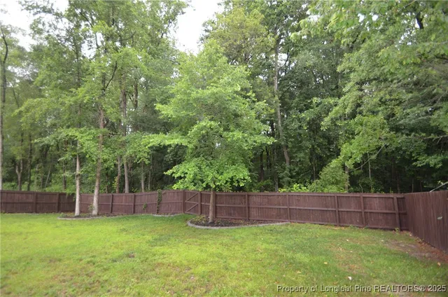 a view of a backyard with a small cabin and wooden fence
