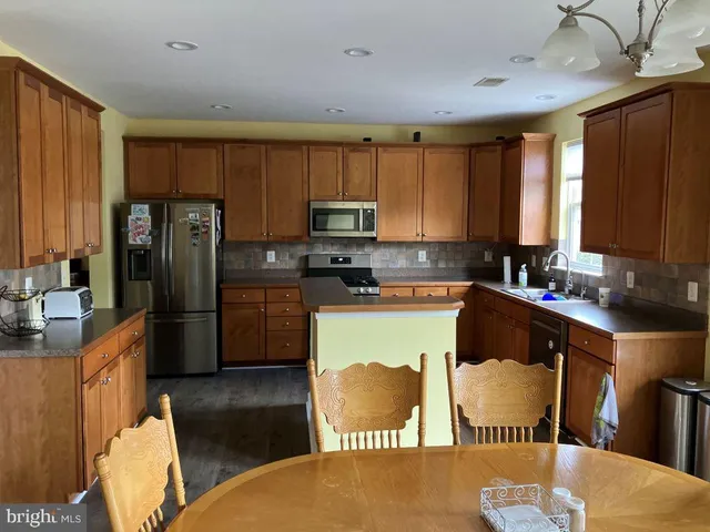 a kitchen with stainless steel appliances granite countertop a refrigerator a stove a sink dishwasher and a microwave