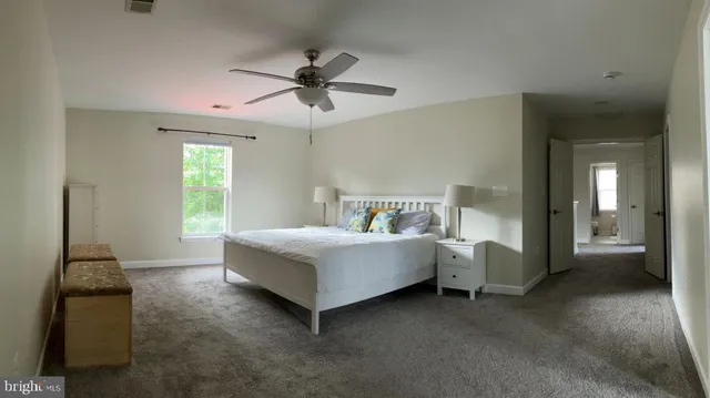 a spacious bedroom with a bed and a chandelier