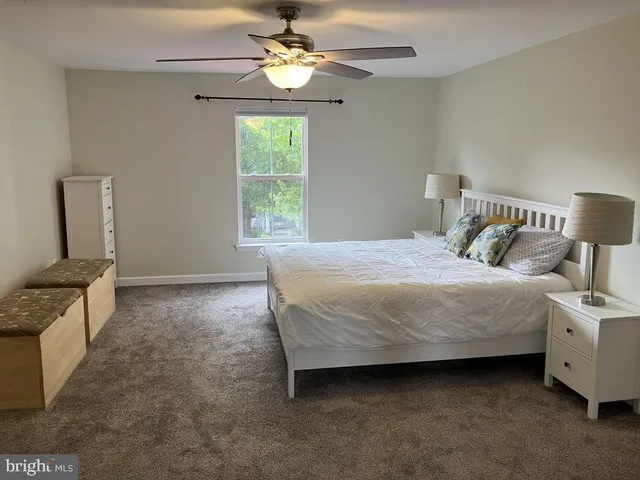 a bedroom with a bed dresser and a window