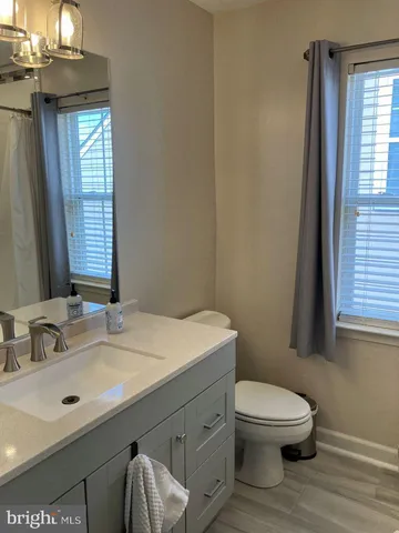 a bathroom with a sink a toilet and window